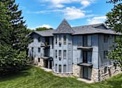 Thumbnail 36 of 41 - A large house with a stone foundation and a balcony.