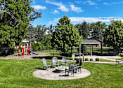 Thumbnail 32 of 41 - A park with a playground, picnic table, and benches.