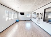 Thumbnail 23 of 41 - A room with wooden floors and exercise equipment.
