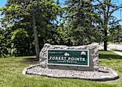 Thumbnail 31 of 41 - A sign for Forest Pointe Apartments sits in front of a grassy area with trees in the background.