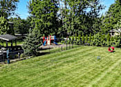 Thumbnail 29 of 41 - A backyard with a playground and a gazebo.
