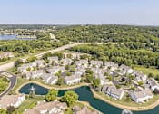 Thumbnail 16 of 16 - A bird's eye view of a residential area with houses surrounding a lake.
