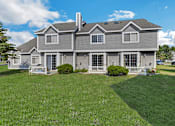 Thumbnail 11 of 16 - A large house with a grey roof and a white fence.