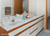 Thumbnail 8 of 16 - A bathroom with a white counter top and a white sink.