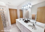 Thumbnail 7 of 16 - A bathroom with a white counter top and a white sink.