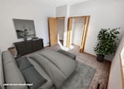 Thumbnail 4 of 16 - A living room with a grey couch and a plant.