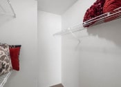 Thumbnail 9 of 30 - a walk in closet with a white wall and a wire rack on the wall