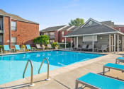 Thumbnail 21 of 30 - a swimming pool with tables and chairs in front of a building