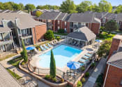 Thumbnail 25 of 30 - an aerial view of a swimming pool in front of an apartment building