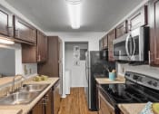 Thumbnail 4 of 30 - a kitchen with stainless steel appliances and wooden cabinets