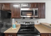Thumbnail 5 of 30 - a kitchen with a stove and a microwave