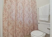 Thumbnail 15 of 26 - apartment bathroom with a toilet and a shower curtain