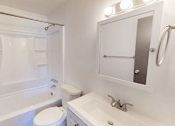 Thumbnail 5 of 28 - A white bathroom with a toilet, sink, and shower.