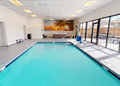 Thumbnail 18 of 28 - A large indoor swimming pool with a mural on the wall.