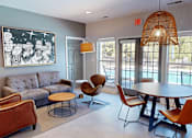 Thumbnail 21 of 27 - a living room with a couch and a table and chairs