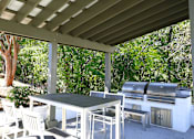 Thumbnail 16 of 27 - a patio with a table and chairs under a roof