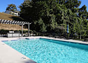 Thumbnail 17 of 27 - a swimming pool with black chairs and a resort style pool