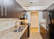 Thumbnail 1 of 13 - apartment kitchen with wood cabinets and granite counter tops and a sink