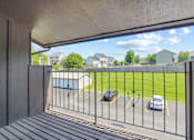 Thumbnail 10 of 32 - A view from a balcony looking out at a parking lot.