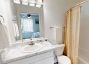 Thumbnail 12 of 33 - A bathroom with a white counter top and a white toilet.