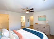 Thumbnail 9 of 33 - A bedroom with a bed, dresser, and ceiling fan.
