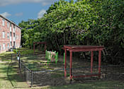 Thumbnail 20 of 33 - A playground with a red swing set and green slide.