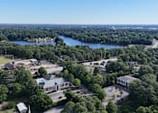 Thumbnail 32 of 33 - A bird's eye view of a residential area with a large body of water in the background.