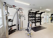 Thumbnail 16 of 33 - A home gym with a variety of equipment including a squat rack, bench, and weightlifting machines.