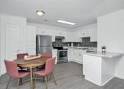 Thumbnail 4 of 33 - An open kitchen with a table and chairs.