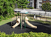 Thumbnail 26 of 33 - A playground with a slide and a green canopy.