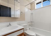 Thumbnail 9 of 20 - A white toilet sits next to a sink in a bathroom.