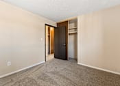 Thumbnail 6 of 20 - A room with a carpeted floor and a door.
