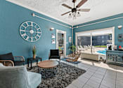 Thumbnail 11 of 20 - A living room with a ceiling fan and a large clock on the wall.