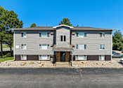 Thumbnail 20 of 20 - A two-story apartment building with a parking lot in front.
