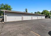 Thumbnail 13 of 20 - A parking lot with a building and four closed garage doors.