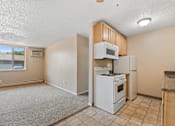 Thumbnail 2 of 20 - A kitchen with a white stove and refrigerator.