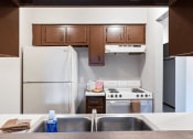 Thumbnail 3 of 18 - a kitchen with white appliances and wooden cabinets and a double bowl sink