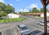 Thumbnail 17 of 18 - a parking lot with cars by an apartment building