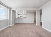Thumbnail 1 of 16 - living room and kitchen of an apartment with carpeting