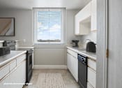 Thumbnail 2 of 16 - A kitchen with white cabinets and a black dishwasher.