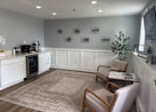 Thumbnail 10 of 26 - A white kitchen with a rug on the floor and two chairs.