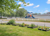 Thumbnail 18 of 26 - a playground in the background with a bunch of flowers in the foreground