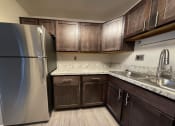 Thumbnail 17 of 18 - a kitchen with wood cabinets and beautiful countertops