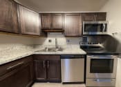 Thumbnail 16 of 18 - a kitchen with dark cabinets and granite countertops