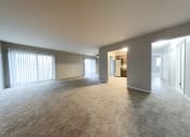Thumbnail 15 of 18 - a spacious living room with a kitchen in the background