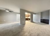 Thumbnail 14 of 18 - a spacious living room with a kitchen in the background