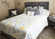 Thumbnail 12 of 31 - a bedroom with a large bed with a white and yellow comforter and pillows