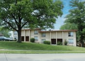 Thumbnail 29 of 31 - a large apartment complex with trees in front of it