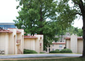 Thumbnail 30 of 31 - an apartment complex with trees in the foreground and a building in the background