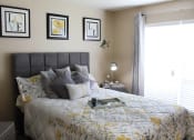 Thumbnail 11 of 31 - a bedroom with a large bed with a white and yellow comforter